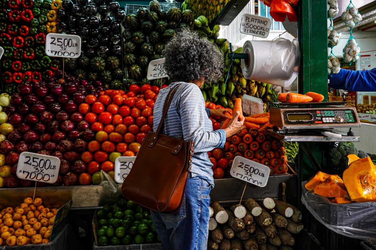 Woman browsing fresh produce at a vibrant market